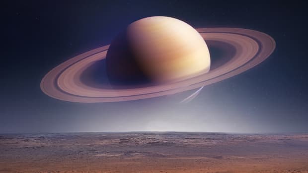 Saturn hovers over a bleak landscape