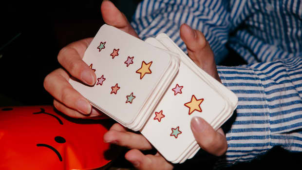 Hands shuffling cards with stars on them.