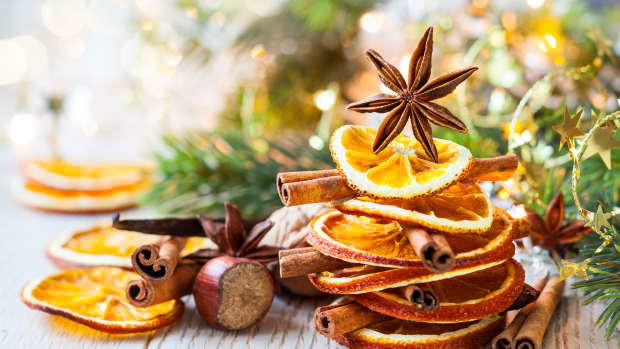 Decoratively stacked dried oranges and cinnamon sticks, topped with a star anise.