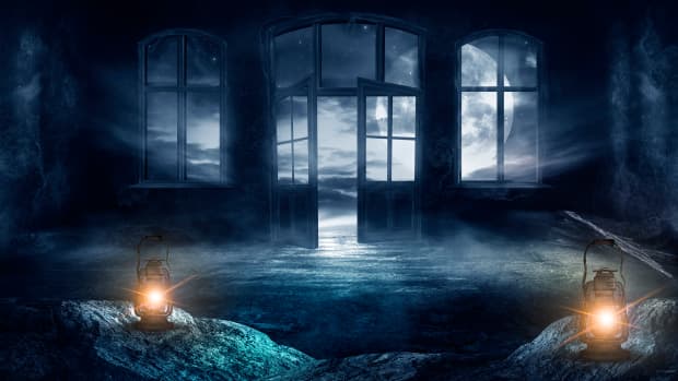 Foggy room with open double doors and two lanterns creating a spooky atmosphere.