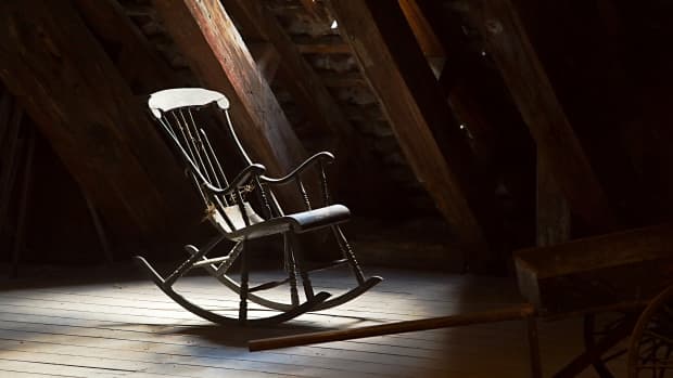 a rocking chair in a dark attic