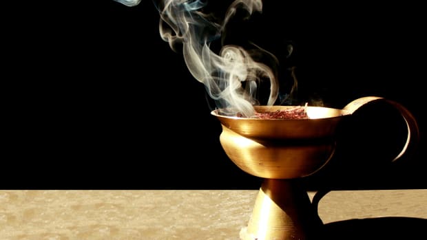 incense or herbs burning in a copper bowl