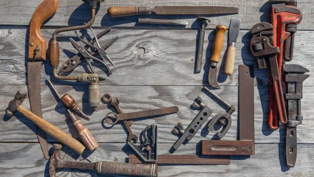 Rustic tools artfully arranged in a retangle against wooden planks