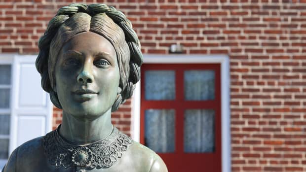 A stone statue of Jennie Wade stands in front of her house in Gettysburg