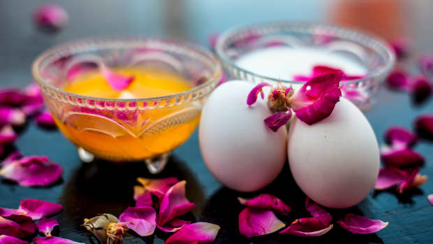 some eggs and flower petals next to filled crystal bowls