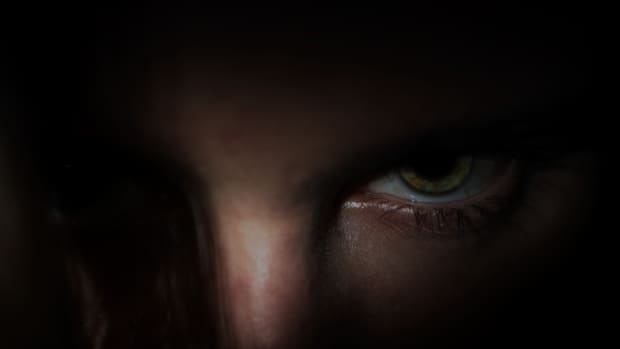 a dark, shadowy photograph of a person glaring evilly