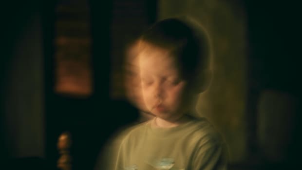a blurry creepy image of a little boy