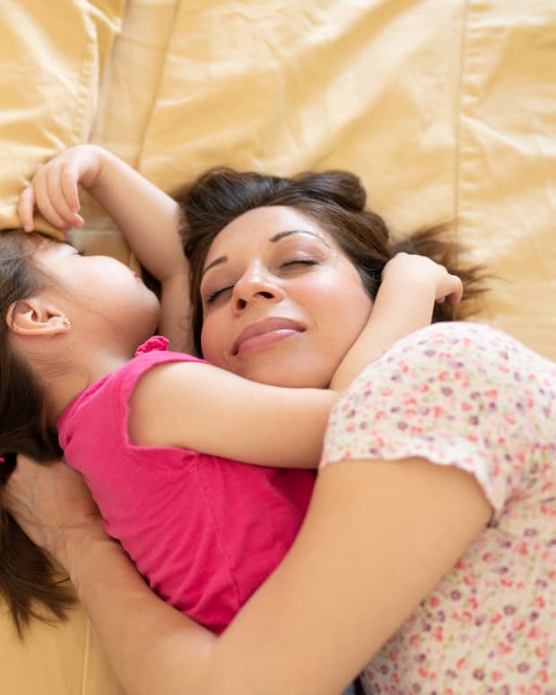 woman sleeping in bed with her daughter