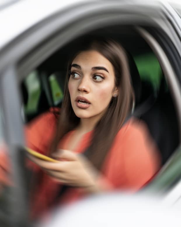 A woman at the wheel of a car but the car image blurs around her