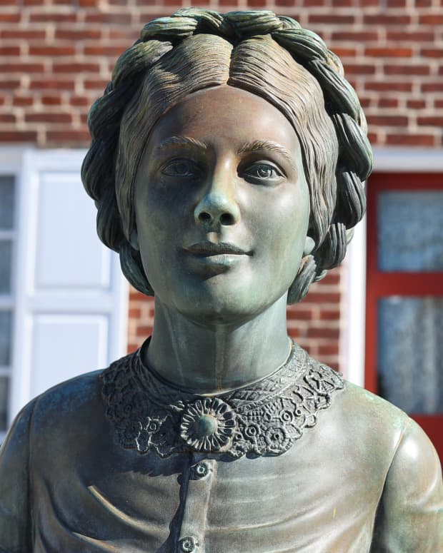 A stone statue of Jennie Wade stands in front of her house in Gettysburg