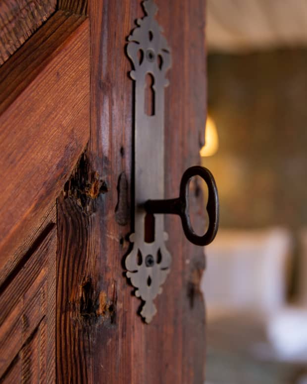 A wrought iron key in an old lock on an antique wooden door