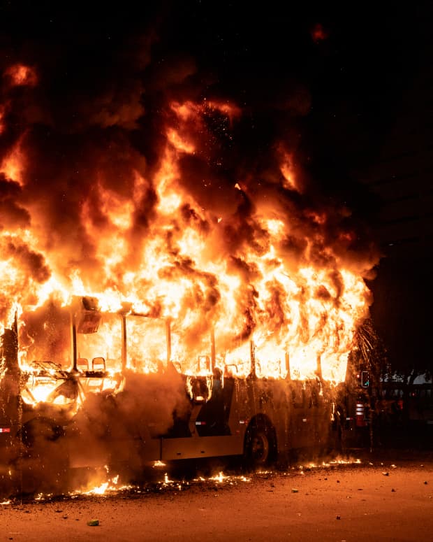 A bus burns in the night.
