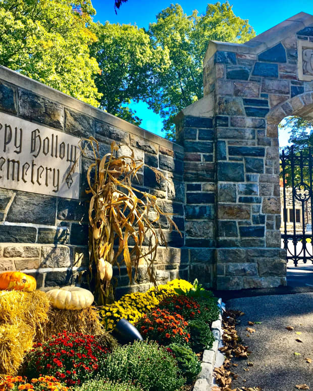 A picturesque shot of the stone walls, iron gate and carved gothic sign of the Sleepy Hollow Cemetery