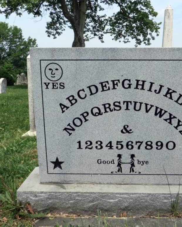A stone headstone printed like a ouija board