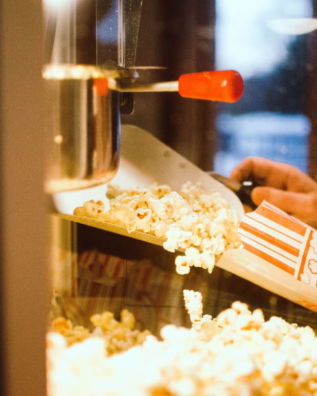 A close up on popcorn being retrieved from a movie theater popcorn popper