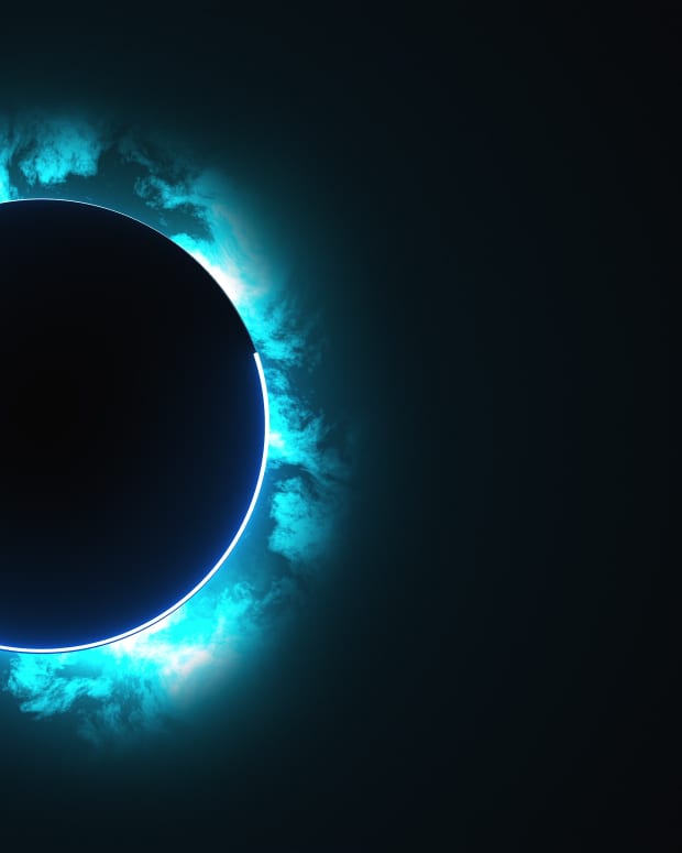 a ring of blue cloudy light around a black circle like an eclipse in the sky