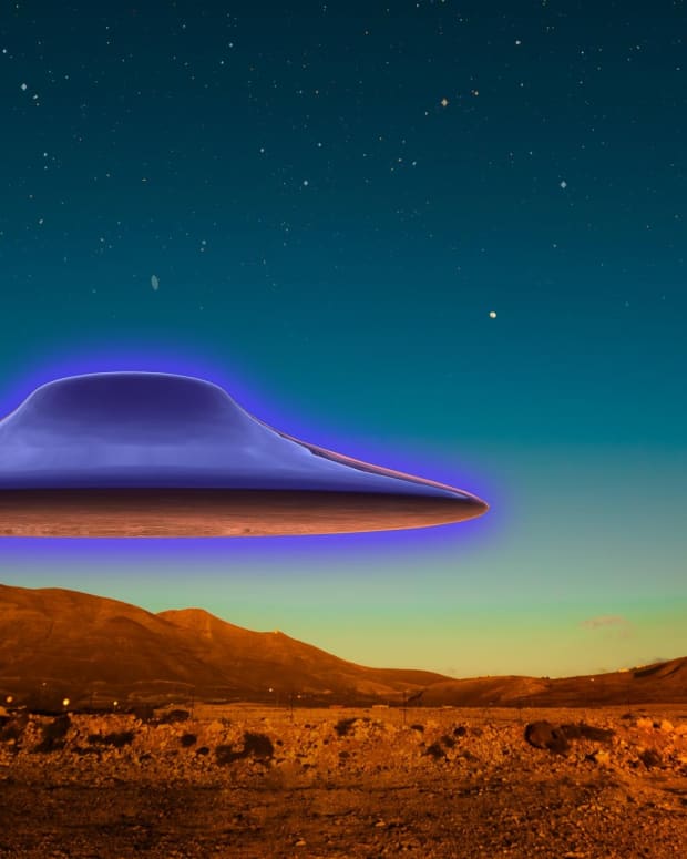 a purple flying saucer glows over a color-saturated desert landscape
