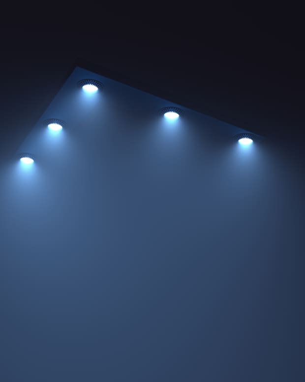 lights shine down through the darkness from the edges of a floating triangle shape