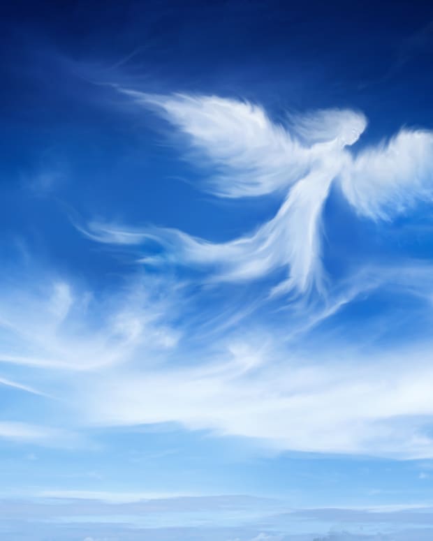an angel shaped like a cloud against a cloudy blue sky