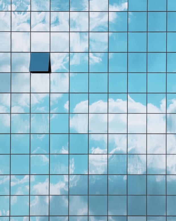 a grid of windows overlaid a blue sky dotted with clouds, with one "window" open