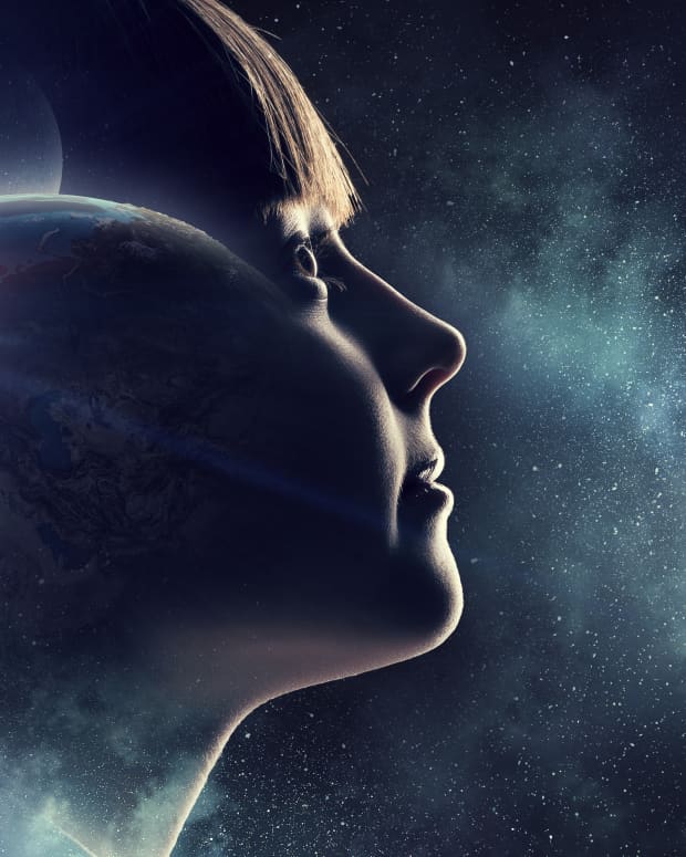a close up double exposed side view of a young child's face superimposed upon planets and stars