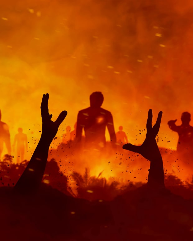in a red and fiery field, hands rise up, grasping, and silhouettes of people wander
