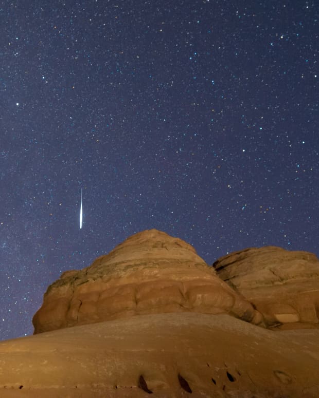 a shooting star over a rock formation in Utah