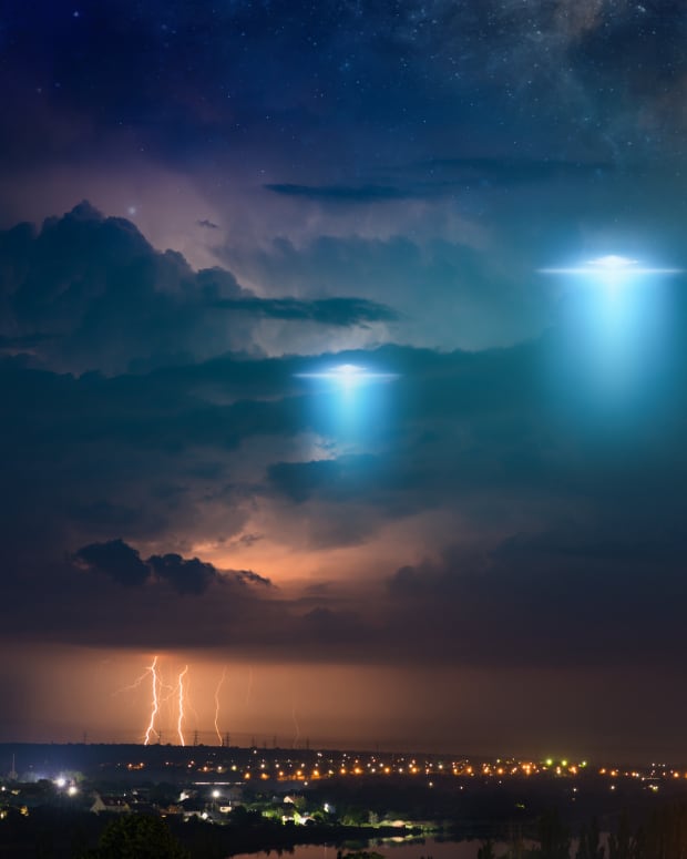 unidentified lights float above a city on a stormy night