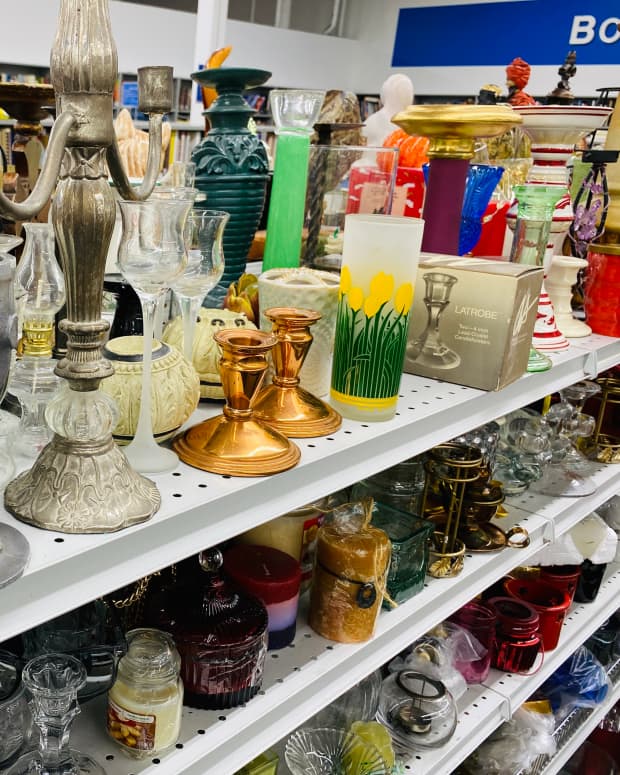 a store shelf crowded with candlesticks and glassware