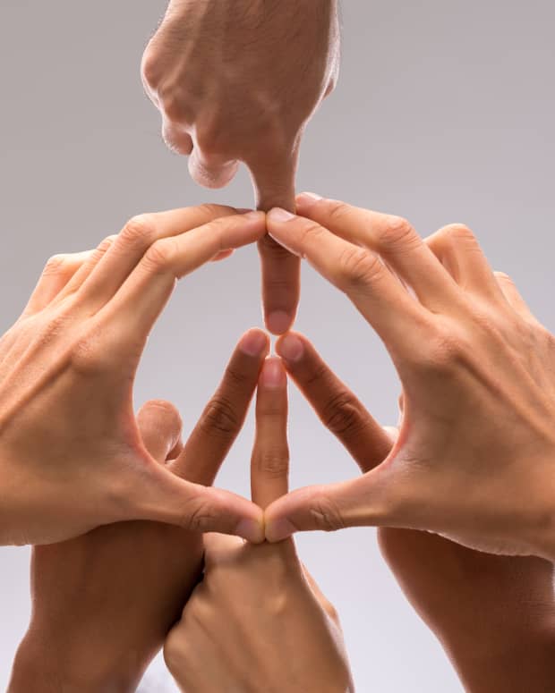 Several hands combine to make a peace sign symbol.