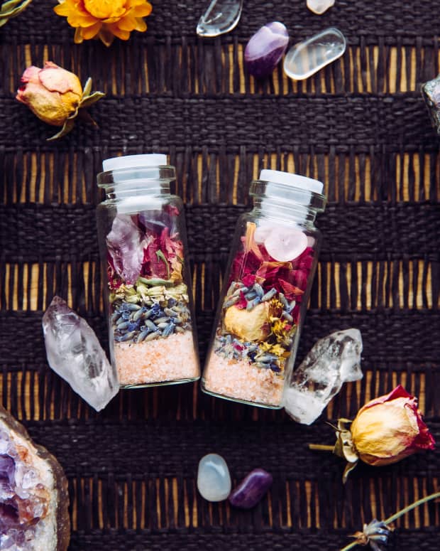 a few stoppered jars filled with herbs, crystals and other witchy items among an array of same.