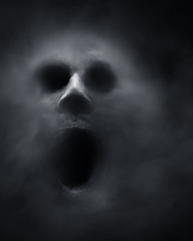 a creepy humanoid ghost face out of smoke