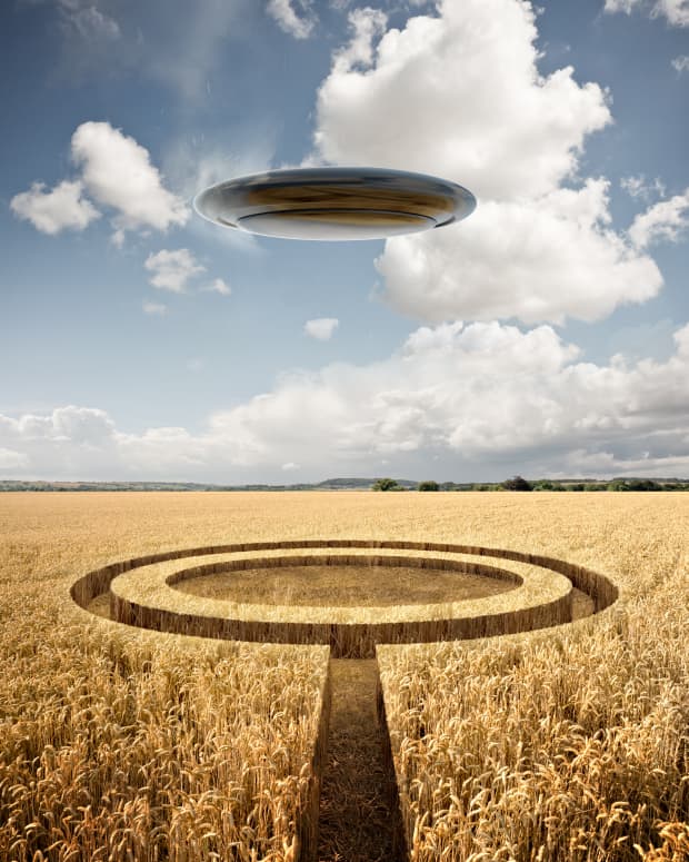 UFO hovering over a field featuring a crop circle