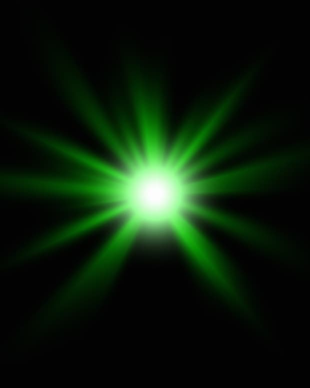a green neon light sparkles, star shaped, in a black field