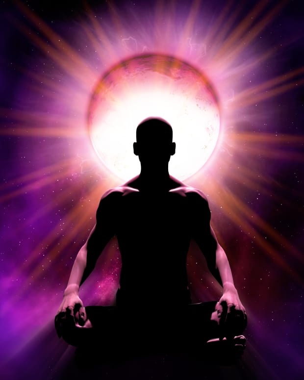 a silhouette of a man sitting in a meditation pose with a light shining haloed around his head.