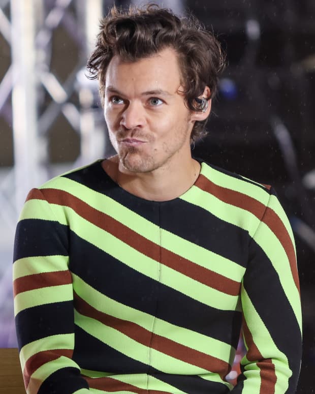 Harry Styles pouts in a green striped sweater in 2022
