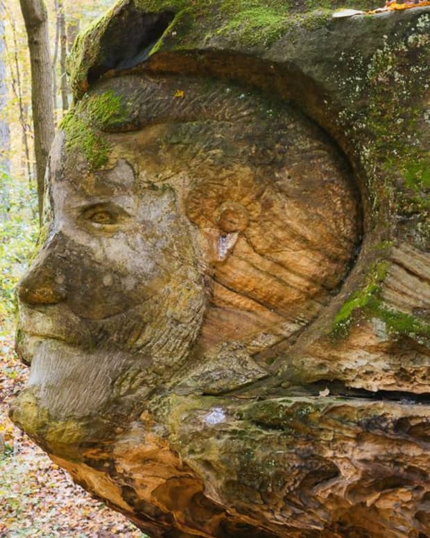 a profile of a stone face carved out of a giant sandstone boulder