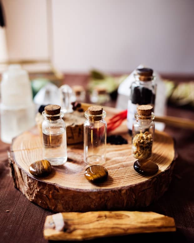 an array of glass bottles with cork stoppers filled with various natural elements on a wooden round