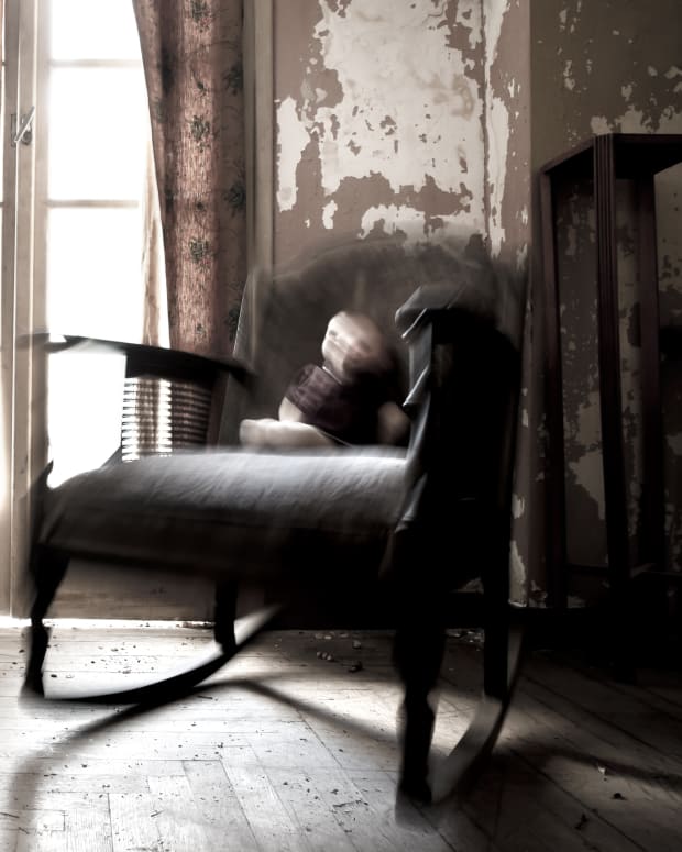 a creepy blurry doll on an old chair in an abandoned house